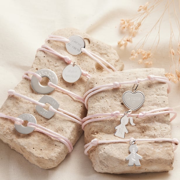 Nature morte de plusieurs bracelets cordons en Argent dont un bracelet cordon avec médaille Argent personnalisée