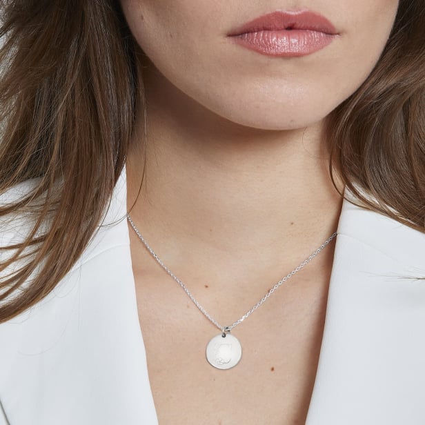 Photo porté du collier personnalisé argent femme avec initiale florale.