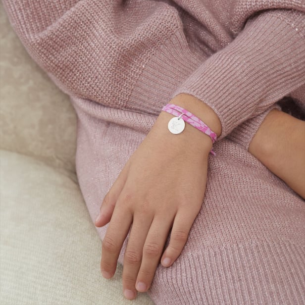 Photo du bracelet personnalisé avec une initiale florale porté sur une jeune fille.