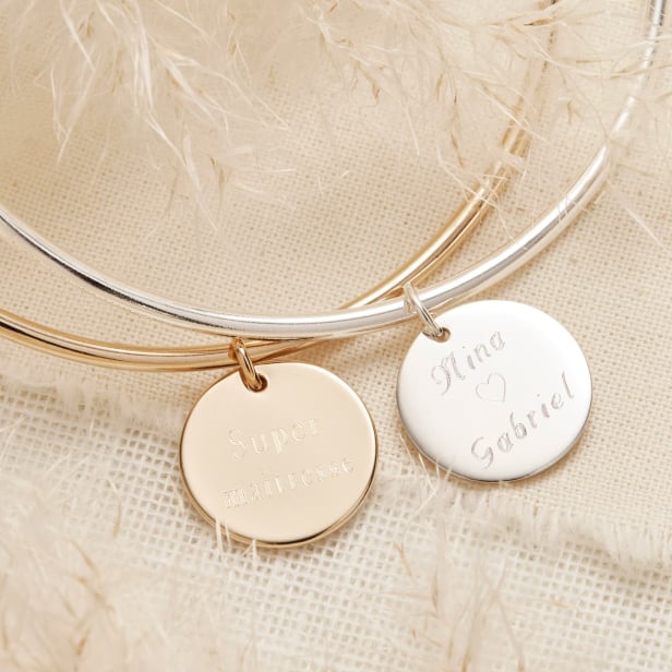 Nature morte comportant un bracelet jonc personnalisé médaille gravée Plaqué Or et le même mais en Argent