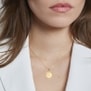 Photo bijou porté sur une femme. Collier personnalisé alphabet floral sur pendentif soleil