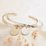 Nature morte du bracelet Plaqué Or jonc martelé et médaille gravée avec également le même jonc mais en Argent