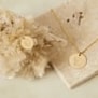 Nature morte colliers personnalisés pour enfant en plaqué or avec des initiales florales